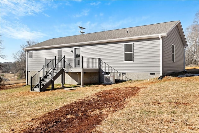 rear view of house featuring central AC, a deck, and a yard