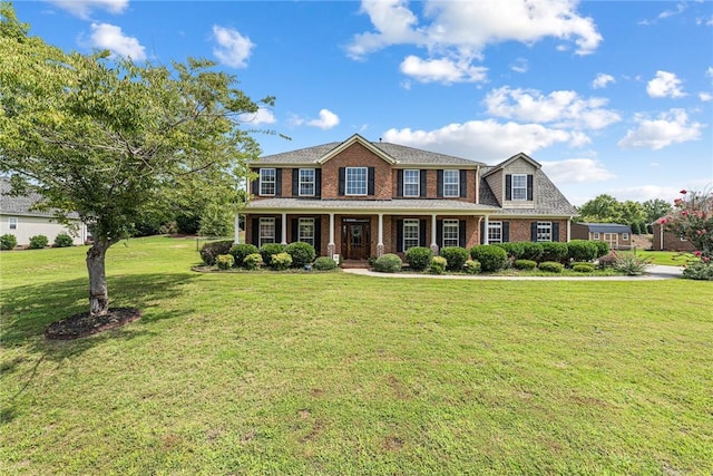 view of front facade with a front yard and covered porch