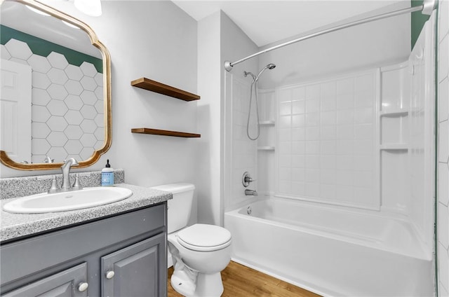 full bathroom with hardwood / wood-style floors, bathtub / shower combination, vanity, and toilet