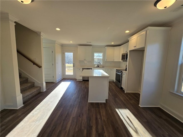 kitchen featuring a center island, dark wood-type flooring, white cabinetry, and appliances with stainless steel finishes