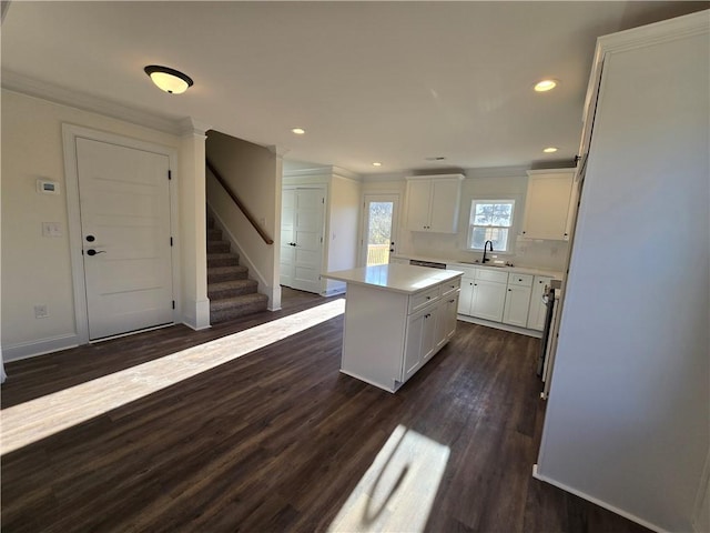 kitchen with dark wood-type flooring, white cabinetry, and a kitchen island