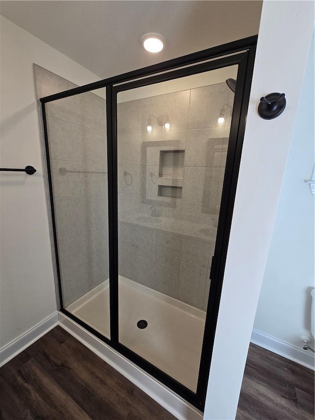 bathroom with an enclosed shower and hardwood / wood-style flooring