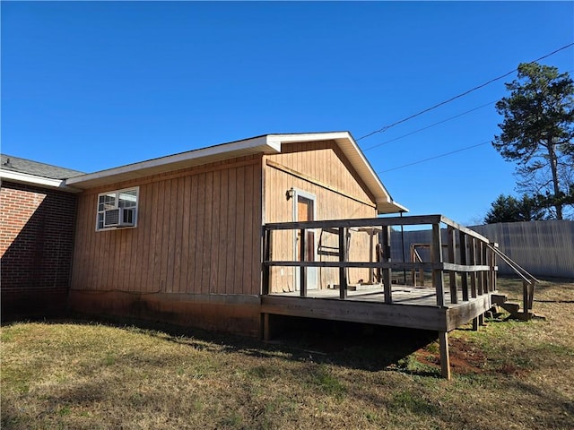 back of property with a deck and a lawn