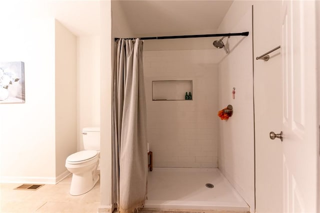 bathroom with toilet, tile patterned flooring, and walk in shower