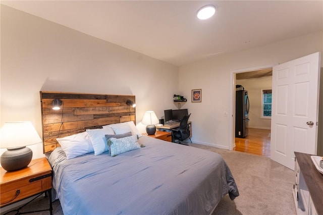 bedroom with light colored carpet and refrigerator