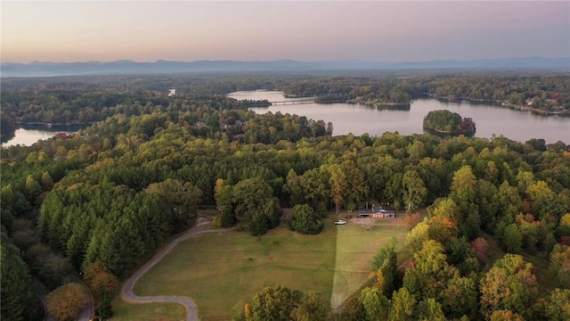 aerial view at dusk featuring a water view