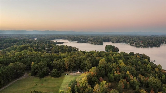 aerial view at dusk featuring a water view