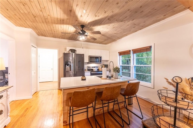 kitchen with white cabinets, stainless steel appliances, wooden ceiling, and a breakfast bar area