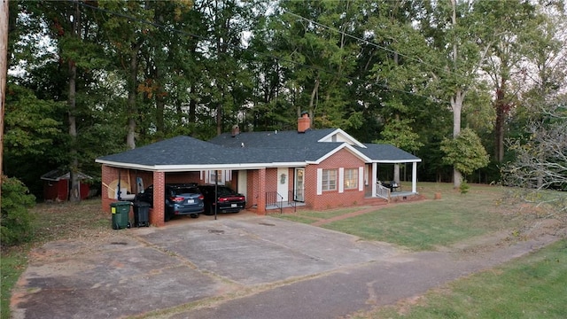 single story home featuring a porch, a carport, and a front lawn