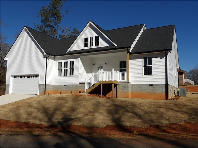 view of front facade featuring central AC, covered porch, and a garage