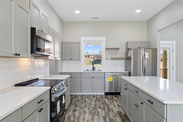 kitchen with a sink, visible vents, light countertops, appliances with stainless steel finishes, and gray cabinets