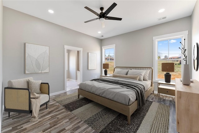 bedroom featuring dark wood-type flooring, recessed lighting, multiple windows, and visible vents