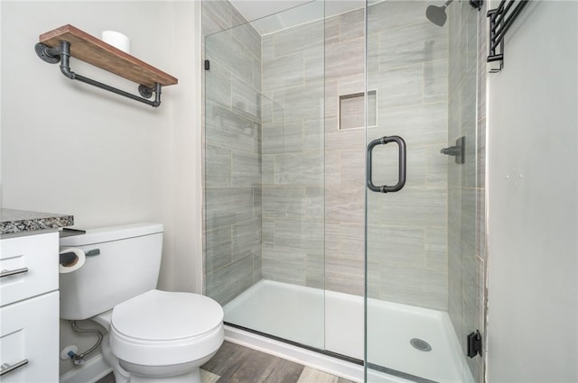 bathroom with walk in shower, vanity, toilet, and hardwood / wood-style floors