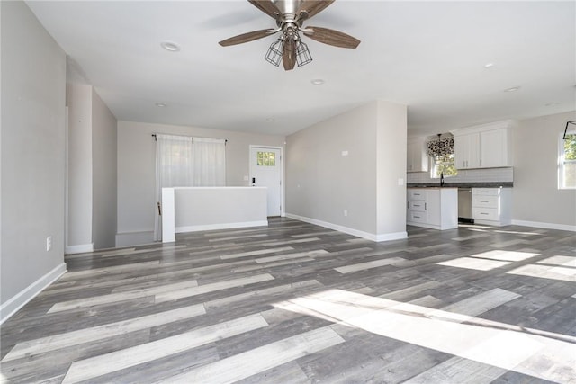 unfurnished living room featuring ceiling fan, hardwood / wood-style flooring, and sink