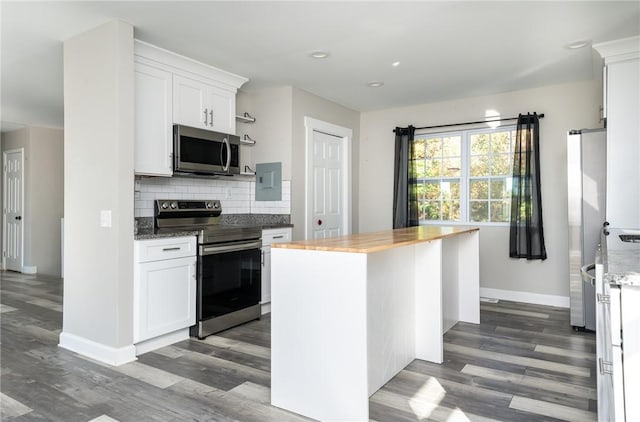 kitchen with a kitchen island, white cabinetry, stainless steel appliances, tasteful backsplash, and butcher block countertops