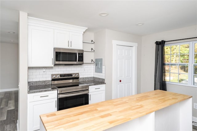 kitchen featuring backsplash, butcher block countertops, white cabinets, and stainless steel appliances