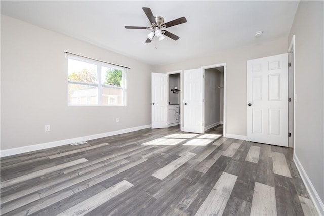 unfurnished bedroom featuring dark wood-type flooring, ceiling fan, and ensuite bath