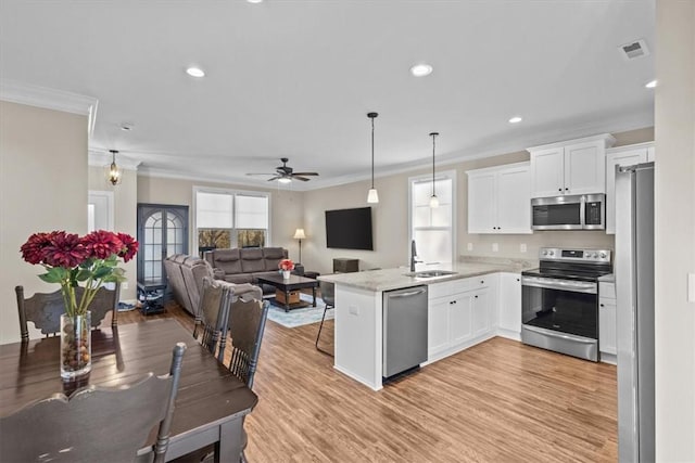 kitchen with sink, white cabinetry, appliances with stainless steel finishes, and kitchen peninsula