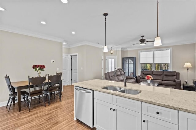 kitchen featuring pendant lighting, stainless steel dishwasher, white cabinets, and sink