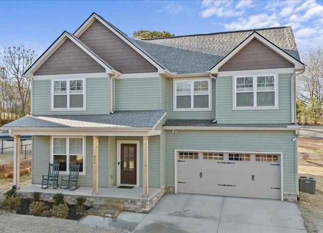 craftsman-style house with covered porch, a garage, and central air condition unit