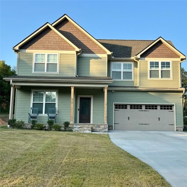 craftsman-style home featuring a front yard, a garage, and a porch