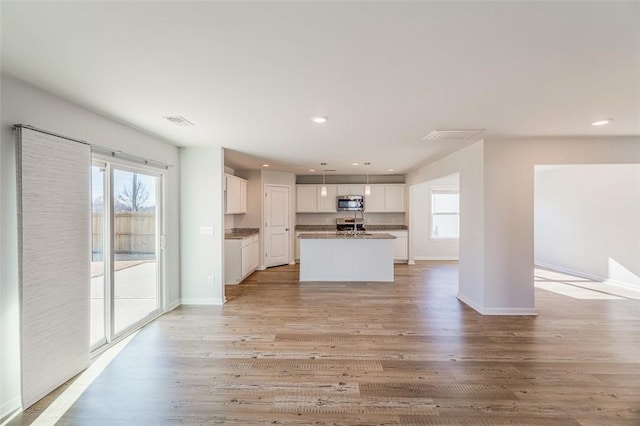 unfurnished living room featuring a healthy amount of sunlight and light hardwood / wood-style floors