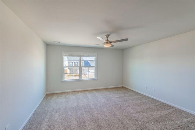 spare room with ceiling fan and light colored carpet