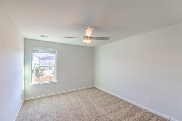 carpeted spare room featuring ceiling fan