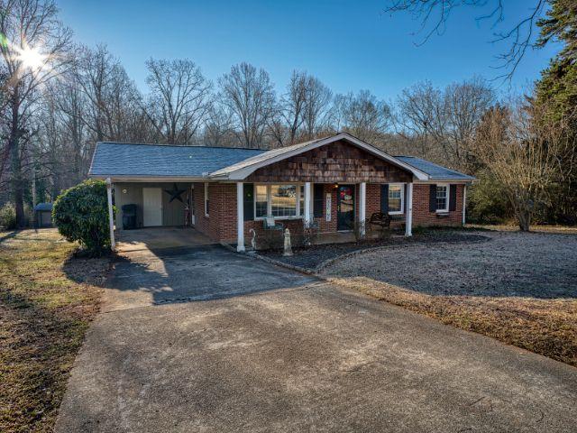 single story home featuring covered porch and a carport