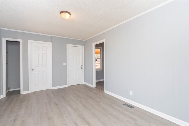 unfurnished bedroom with crown molding, a textured ceiling, and light hardwood / wood-style flooring