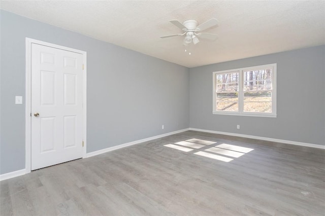 spare room with a textured ceiling, ceiling fan, and light hardwood / wood-style flooring