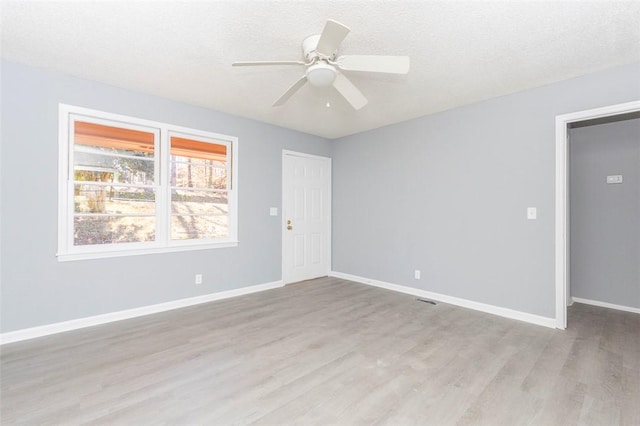 unfurnished room featuring ceiling fan, a textured ceiling, and light wood-type flooring