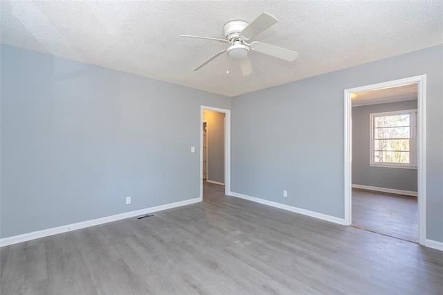 spare room featuring ceiling fan, a textured ceiling, and light hardwood / wood-style flooring