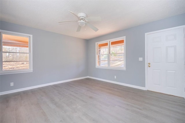 empty room featuring ceiling fan, a textured ceiling, and light wood-type flooring