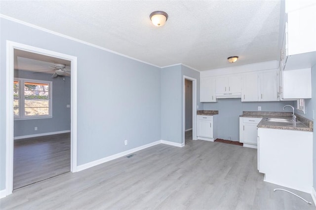 kitchen with ceiling fan, sink, light hardwood / wood-style flooring, a textured ceiling, and white cabinets