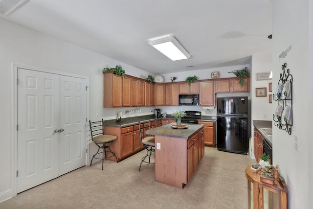 kitchen featuring black appliances, a kitchen breakfast bar, and a center island