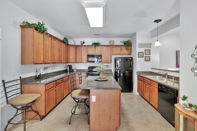 kitchen with black appliances, a center island, sink, hanging light fixtures, and a breakfast bar