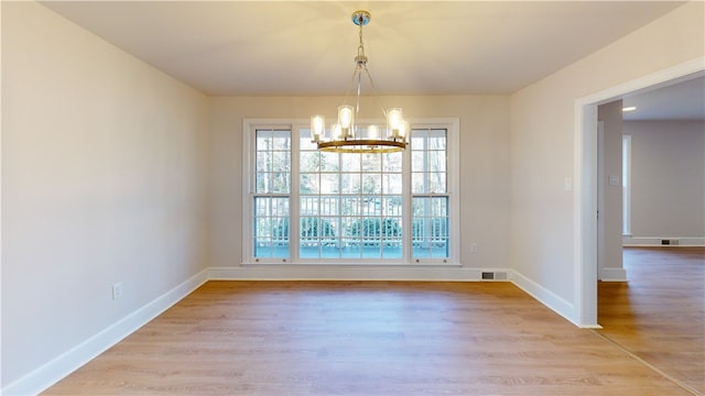 unfurnished dining area with light hardwood / wood-style flooring and an inviting chandelier