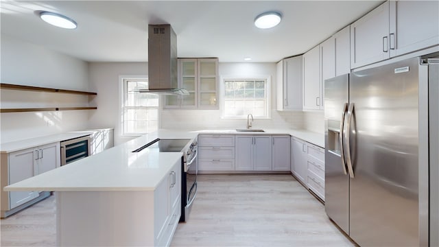 kitchen featuring white cabinetry, island exhaust hood, stainless steel appliances, wine cooler, and sink