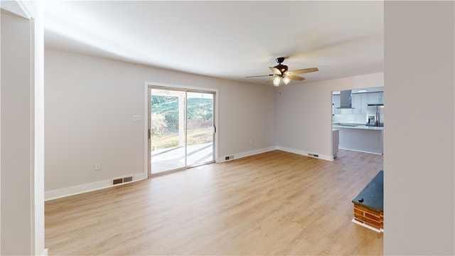 unfurnished living room featuring ceiling fan and light hardwood / wood-style flooring