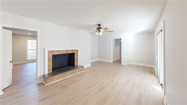 unfurnished living room featuring ceiling fan, a fireplace, and light wood-type flooring