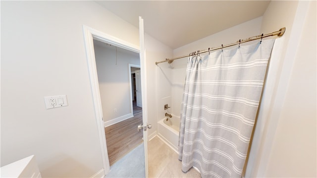 bathroom featuring hardwood / wood-style flooring and shower / tub combo with curtain