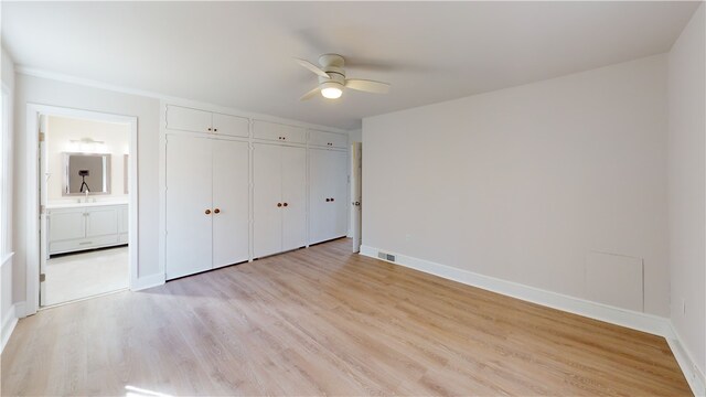 unfurnished bedroom with ceiling fan, light hardwood / wood-style floors, connected bathroom, and sink