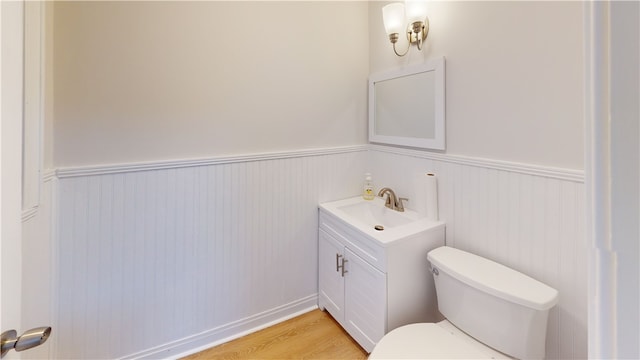 bathroom featuring hardwood / wood-style flooring, toilet, and vanity