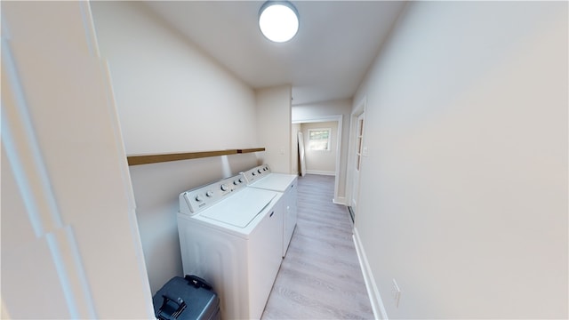 clothes washing area with light wood-type flooring and washing machine and clothes dryer