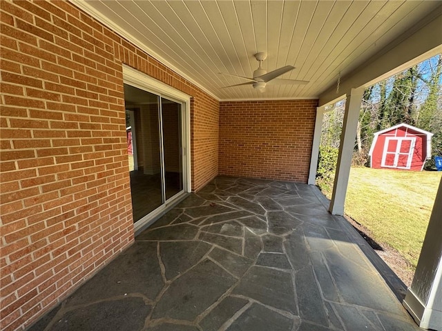 view of patio featuring ceiling fan and a storage unit