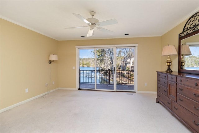 carpeted spare room with ceiling fan and crown molding