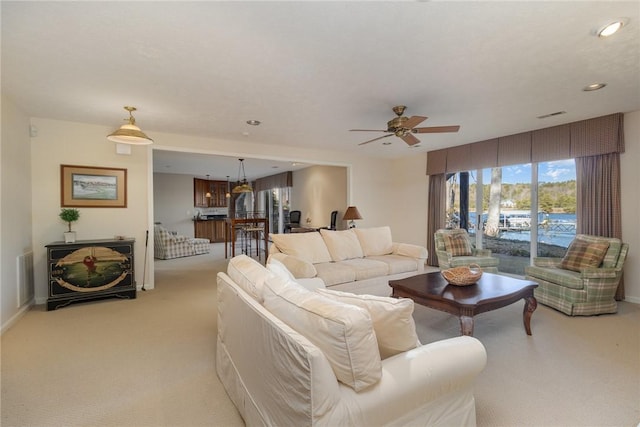 living room featuring light carpet and ceiling fan