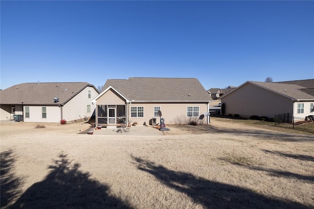 rear view of house with a patio area, fence, and a sunroom