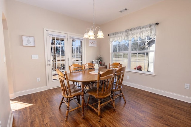 dining space with dark wood-style floors, visible vents, a chandelier, and baseboards